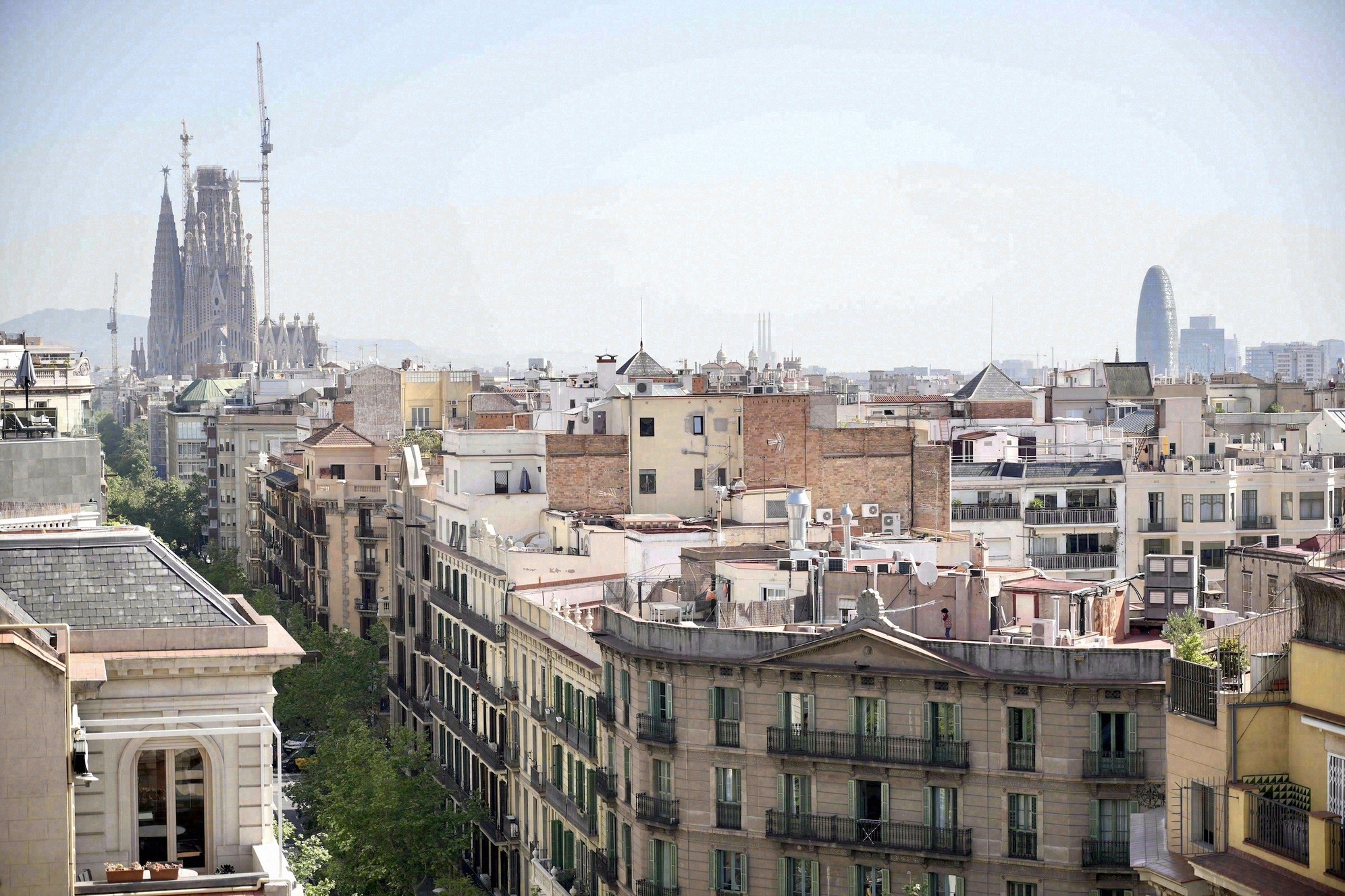Laaja näkymä Casa Milàn katolta Eixamplen kaupunginosan yli, vasemmalla Sagrada Família ja oikealla Torre Agbar utuisessa ilmassa.