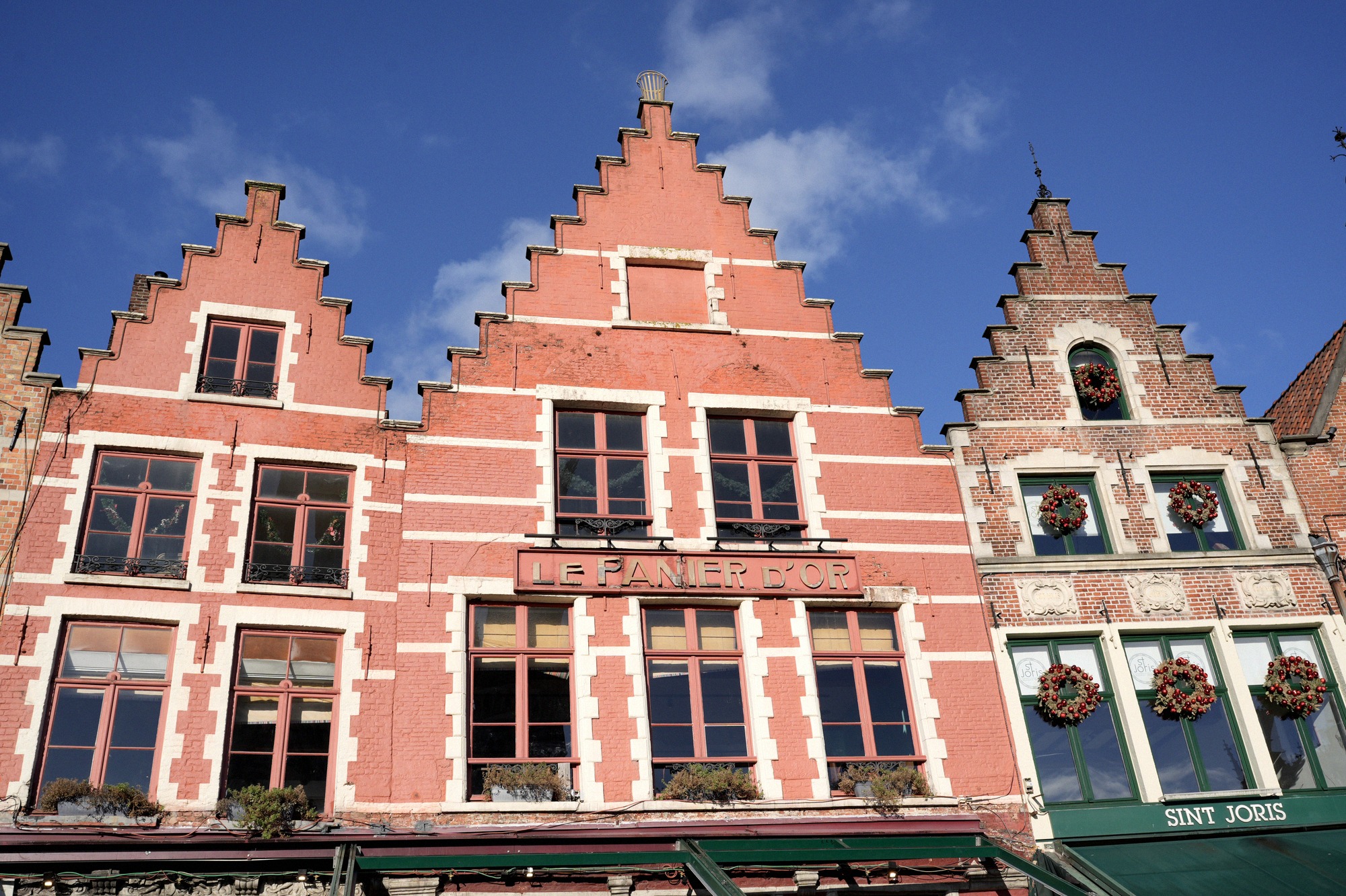 Bruggen goottilainen raatihuone (Stadhuis) Burg-aukiolla Belgian ja kaupungin lippuineen. Myöhäisgoottilainen 1300-luvun rakennus on Alankomaiden vanhimpia raatihuoneita.