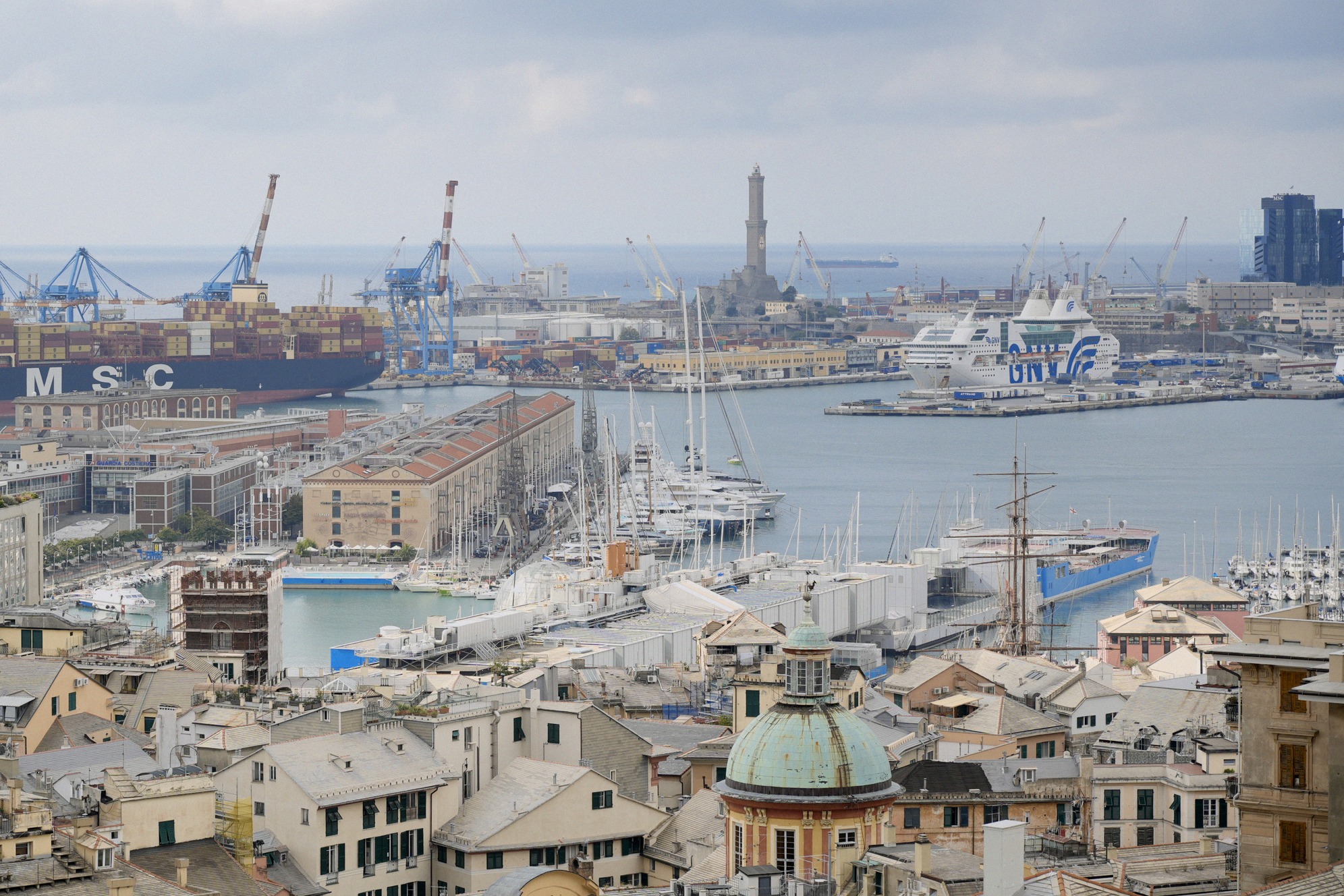 Näkymä Genovan Piazza De Ferrarille, jossa hop on hop off -kiertoajelubussi (Genova Carugi Turismo). Taustalla vaikuttava Teatro Carlo Felice -oopperatalo ja muita keskustan historiallisia renessanssirakennuksia.