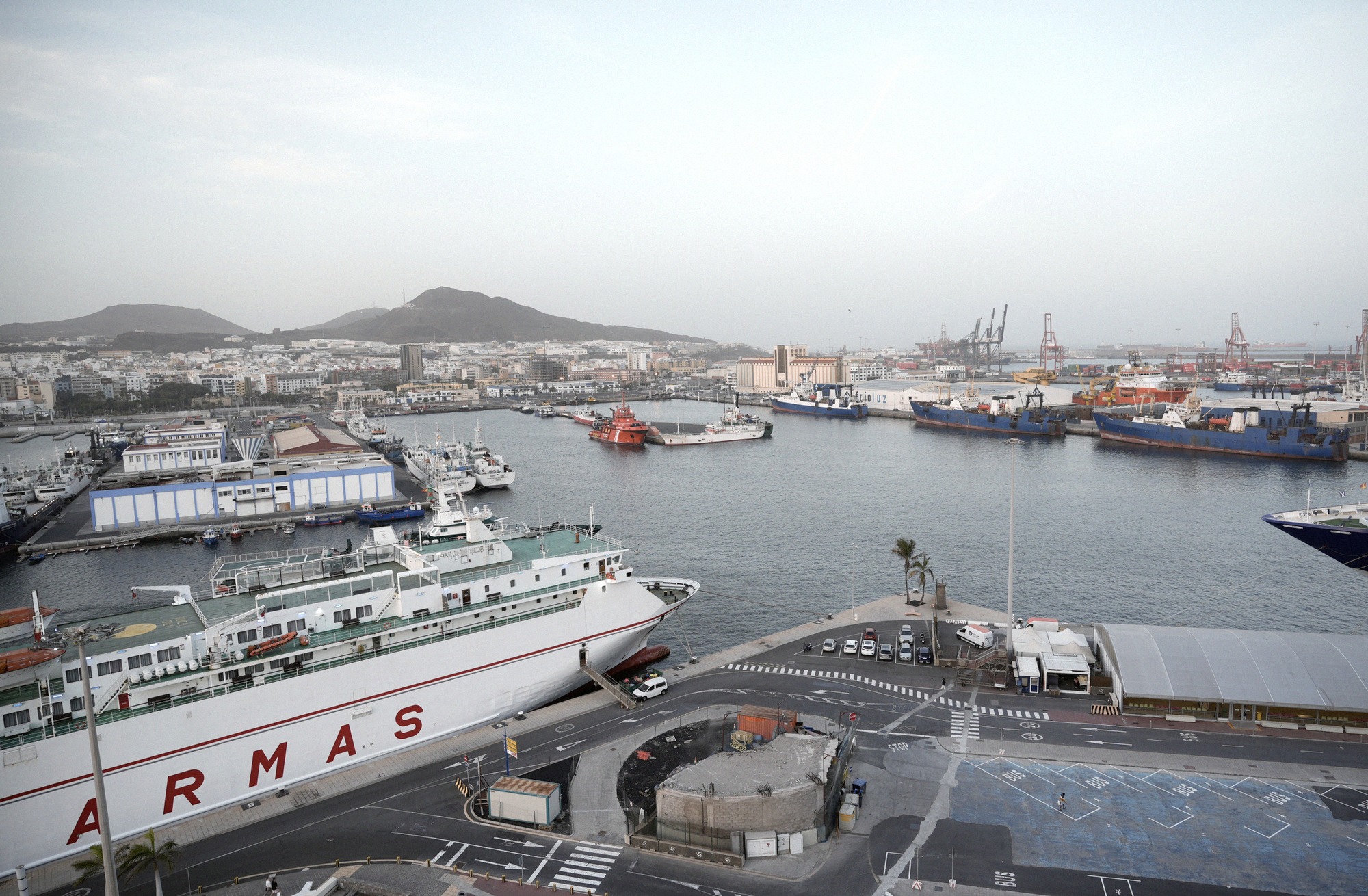 Suuri satamapanoraama Las Palmasista rahti- ja lauttalaivoineen (Naviera Armas) Puerto de La Luzissa. Satama ja kaupungin siluetti ylhäältä.