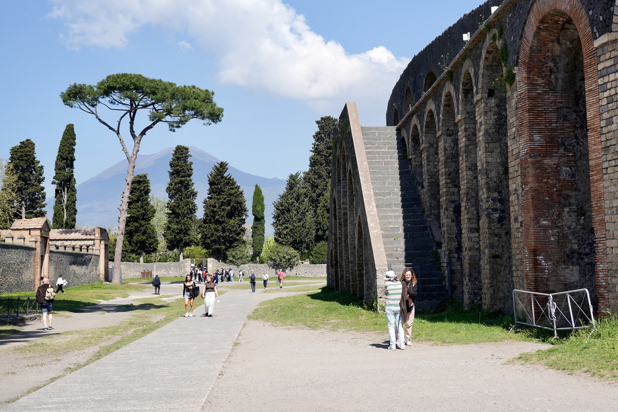 Pompejin amfiteatterin kaarimuuri, takana pinjoja ja Vesuvius.