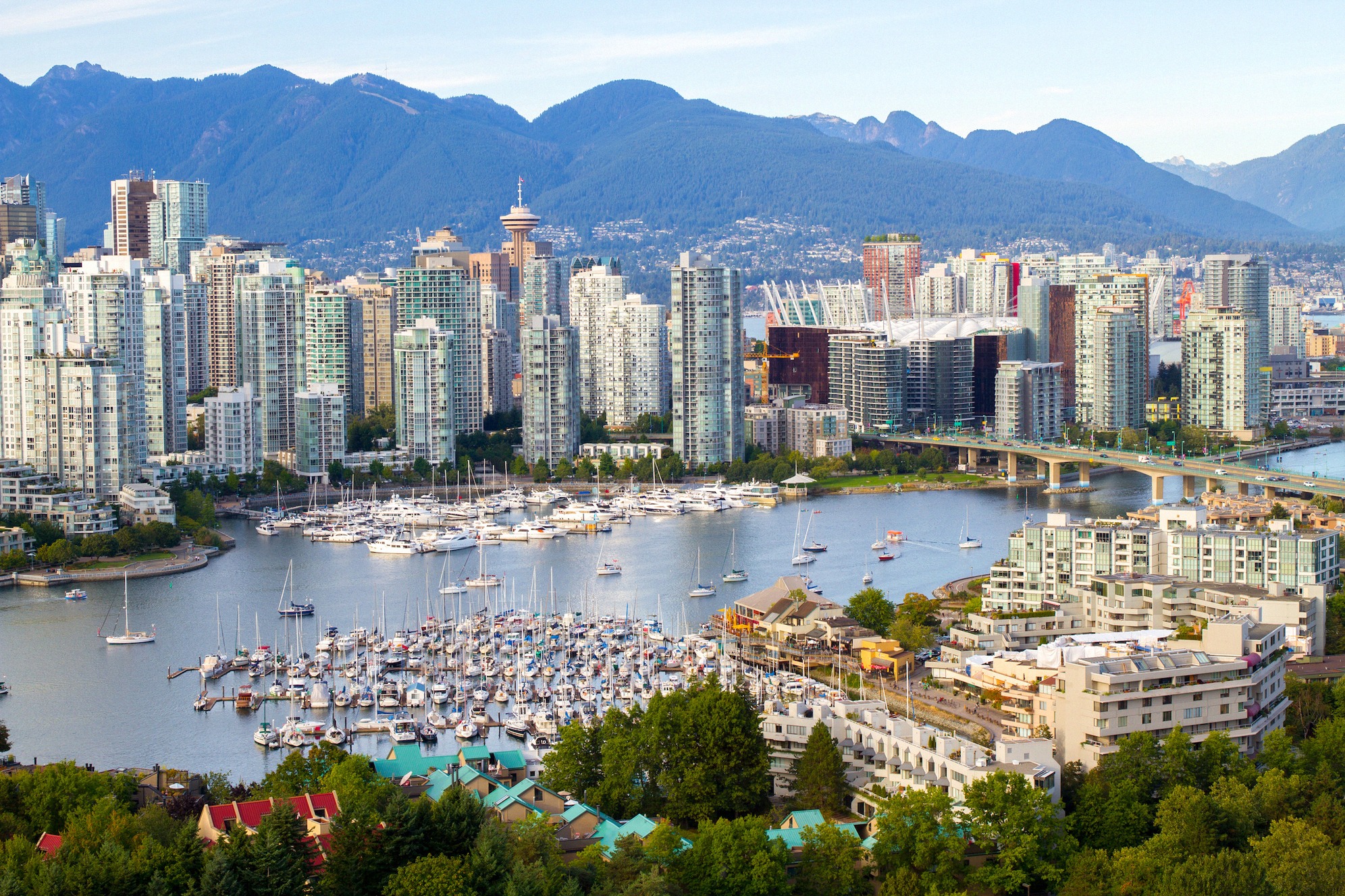 Klassinen näkymä Vancouveriin: tiivis Downtownin siluetti, BC Place, Canada Place ja purjeveneiden täyttämä Yaletownin satama Coast Mountainsin kehystämänä.