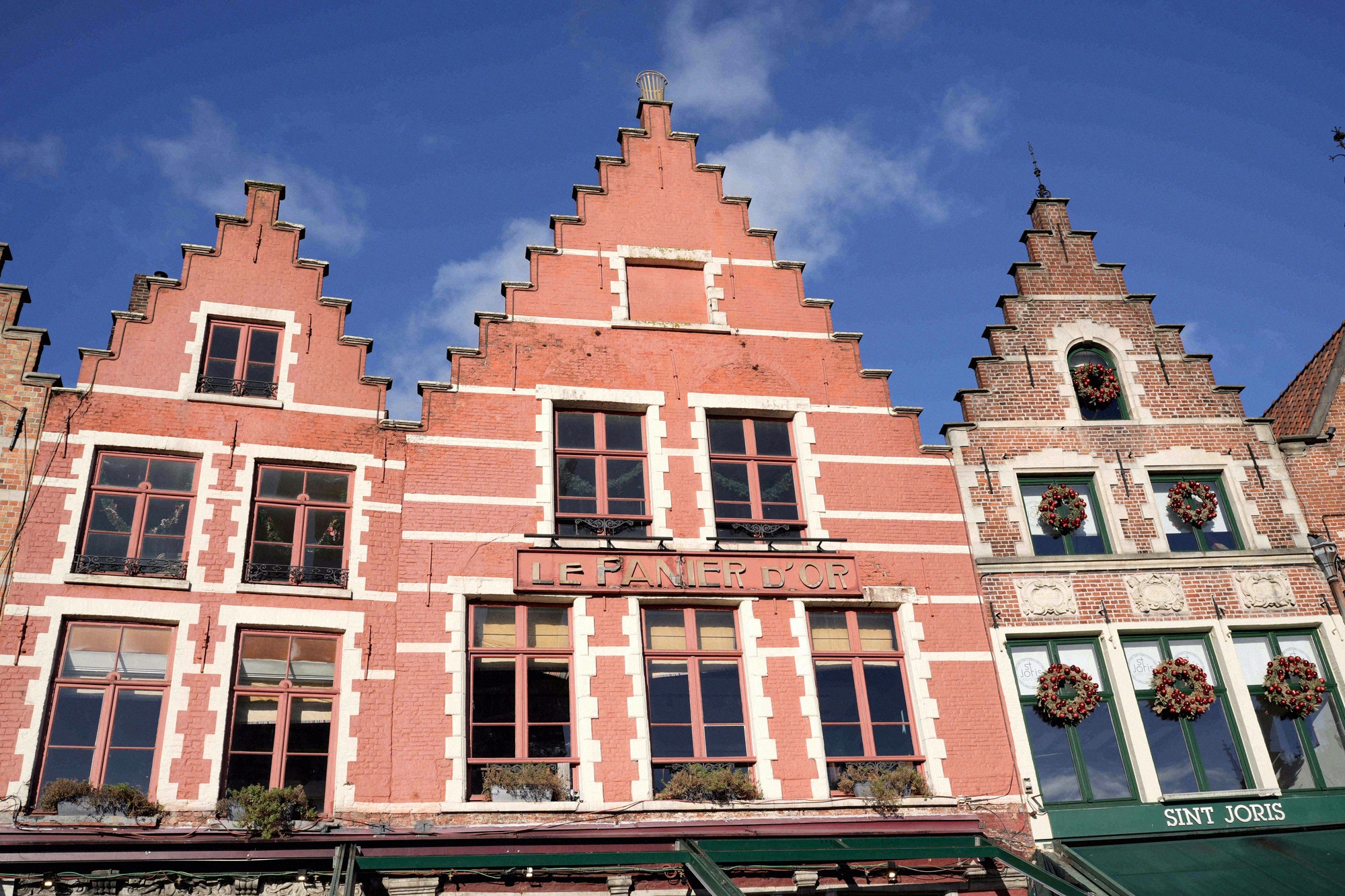 Bruggen goottilainen raatihuone (Stadhuis) Burg-aukiolla Belgian ja kaupungin lippuineen. Myöhäisgoottilainen 1300-luvun rakennus on Alankomaiden vanhimpia raatihuoneita.