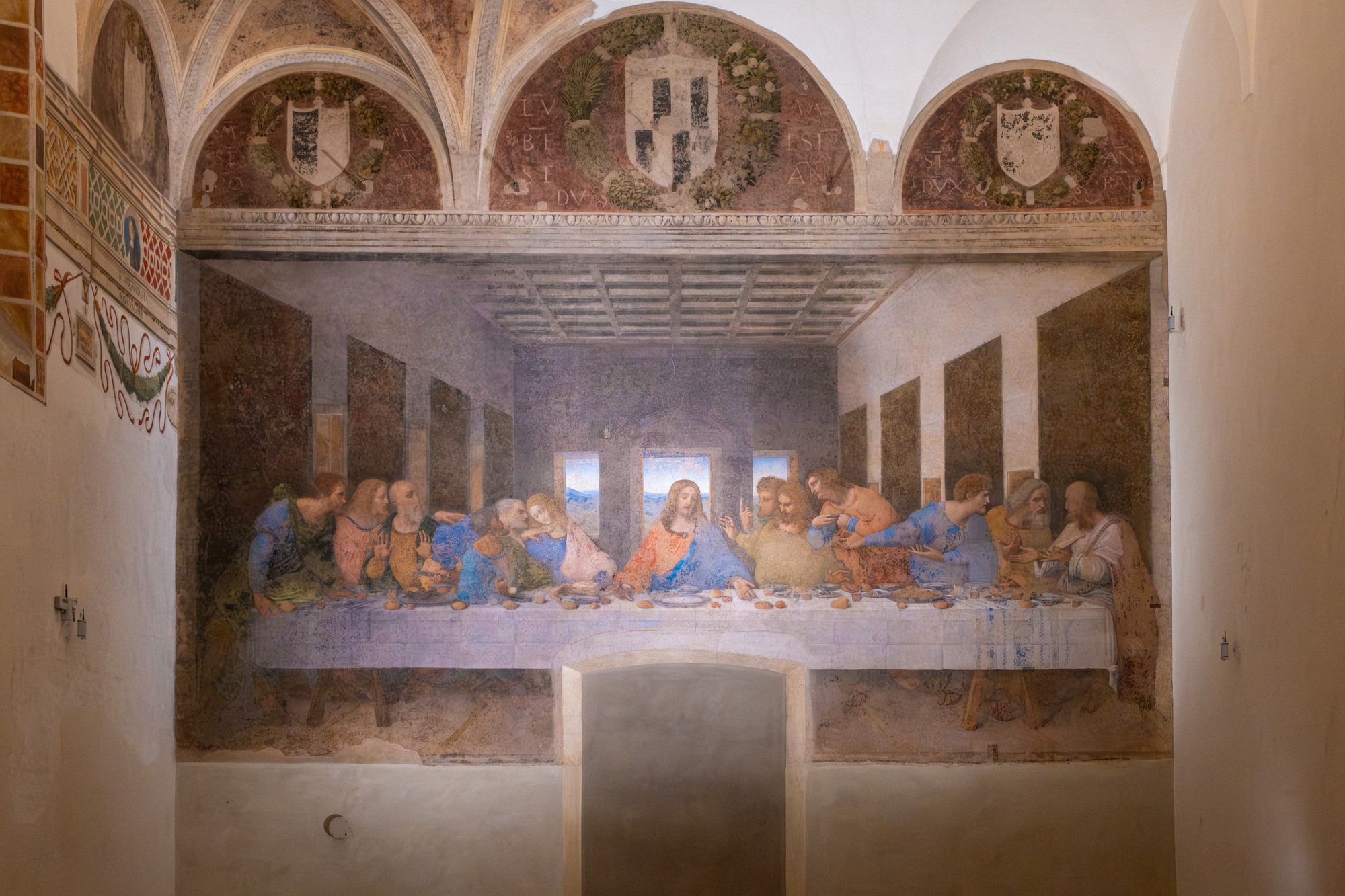 Leonardo da Vincin seinämaalaus Pyhä ehtoollinen Santa Maria delle Grazien ruokasalissa Milanossa, yläpuolella maalatut lunetit.