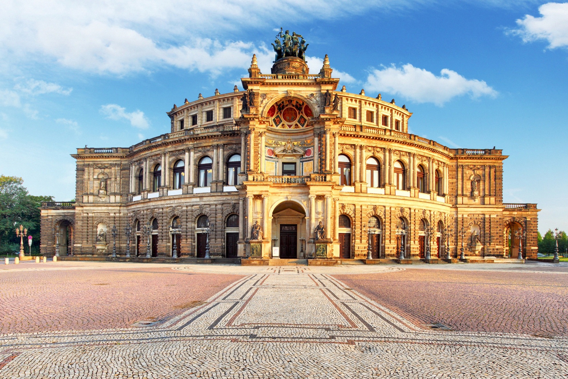 Semperoper Dresdenin Theaterplatzilla, uusbarokkinen oopperatalo komeine julkisivukoristeineen ja kvadrigoineen on yksi maailman kauneimmista oopperataloista.