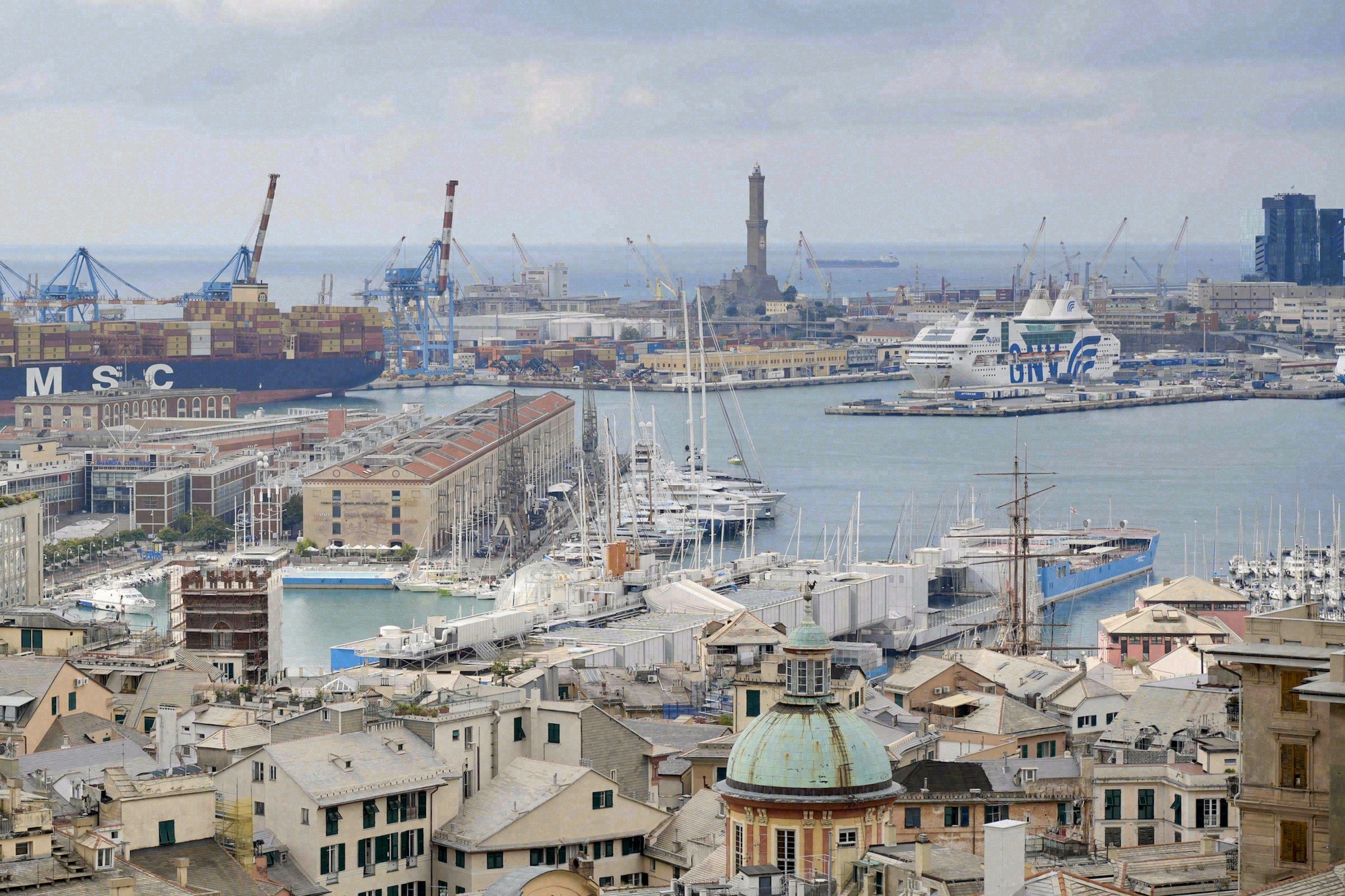 Näkymä Genovan Piazza De Ferrarille, jossa hop on hop off -kiertoajelubussi (Genova Carugi Turismo). Taustalla vaikuttava Teatro Carlo Felice -oopperatalo ja muita keskustan historiallisia renessanssirakennuksia.