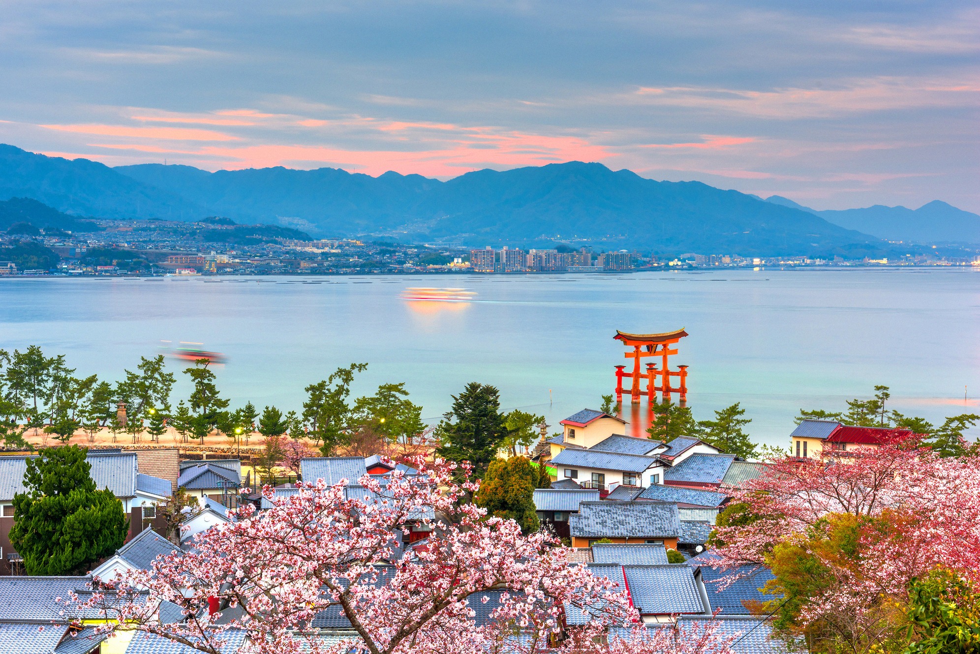 Klassinen japanilainen näkymä, taustalla lumihuippuinen Fuji-vuori ja punainen torii-portti kalliokielekkeellä meressä. Ikoninen kuva yhdistää Japanin pyhän vuoren ja shinto-pyhäkön rannikolla lähellä Hayamaa.