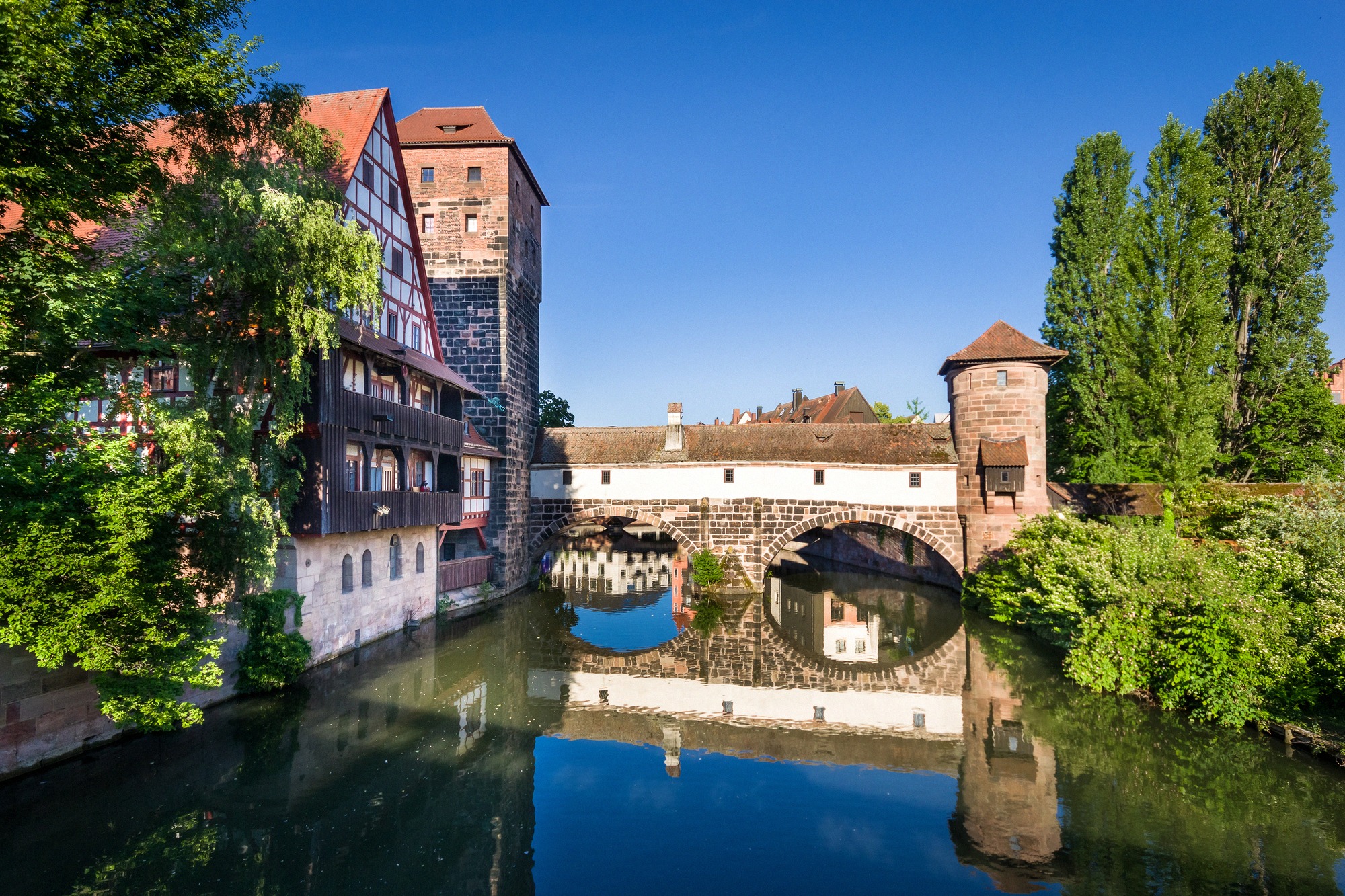 Historiallinen Maxbrücke-silta Pegnitz-joen yli sekä keskiaikainen Weinstadel ja vesitorni, jotka heijastuvat tyynestä vedestä