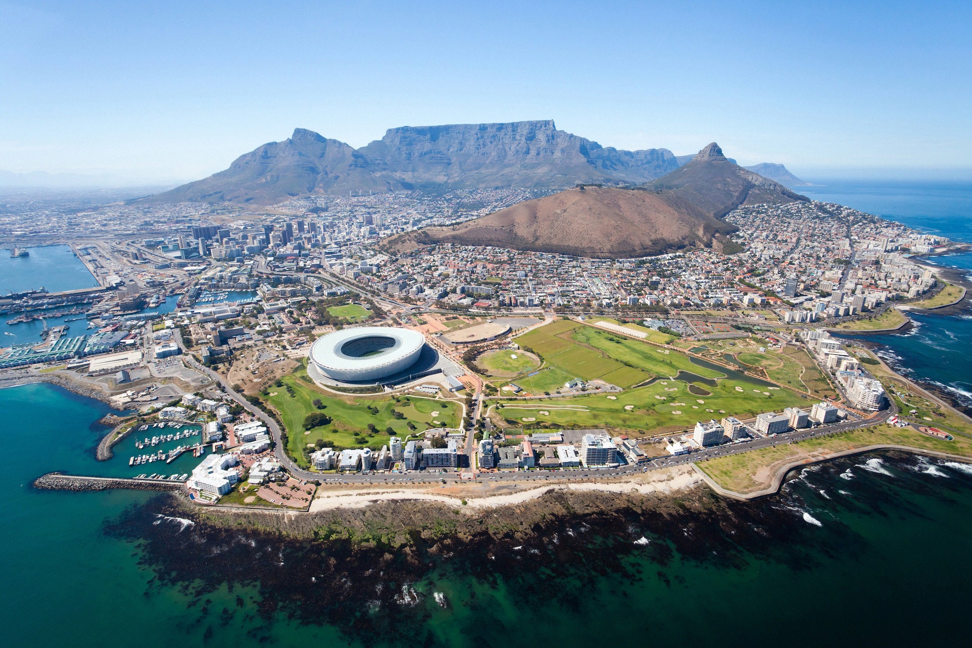 Ikoninen ilmakuva Kapkaupungista, taustalla erottuva Taffelvuori, Cape Town Stadium ja niemimaa Atlantin ja Taffelinlahden välissä.